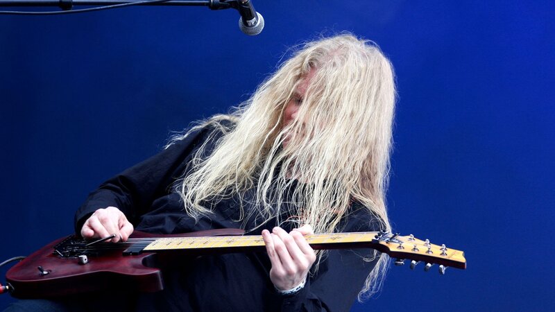 Person Playing Electric Guitar — Blue, Focused