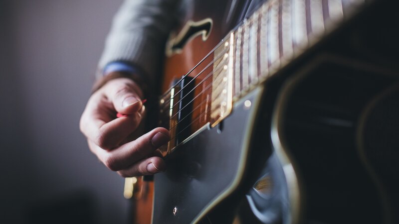 Person Playing Guitar — Brown, Focused, Photograph