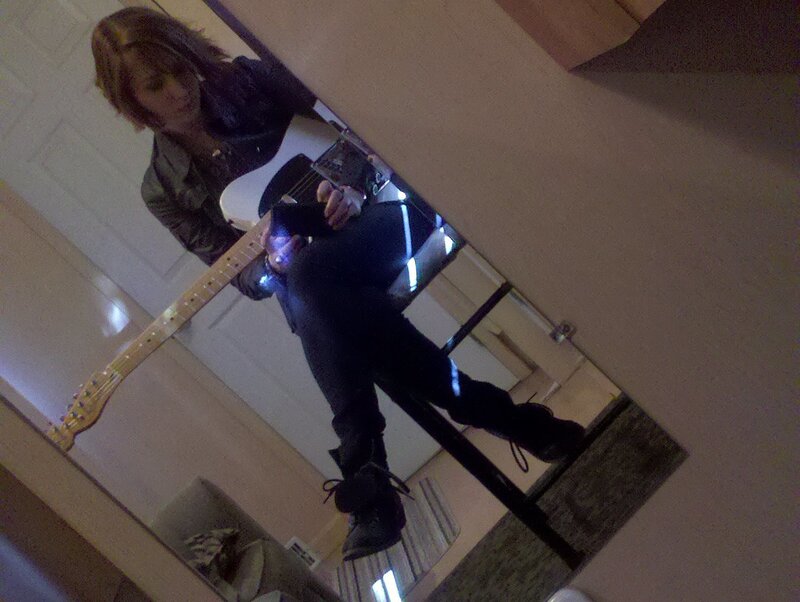 person playing guitar in mirror