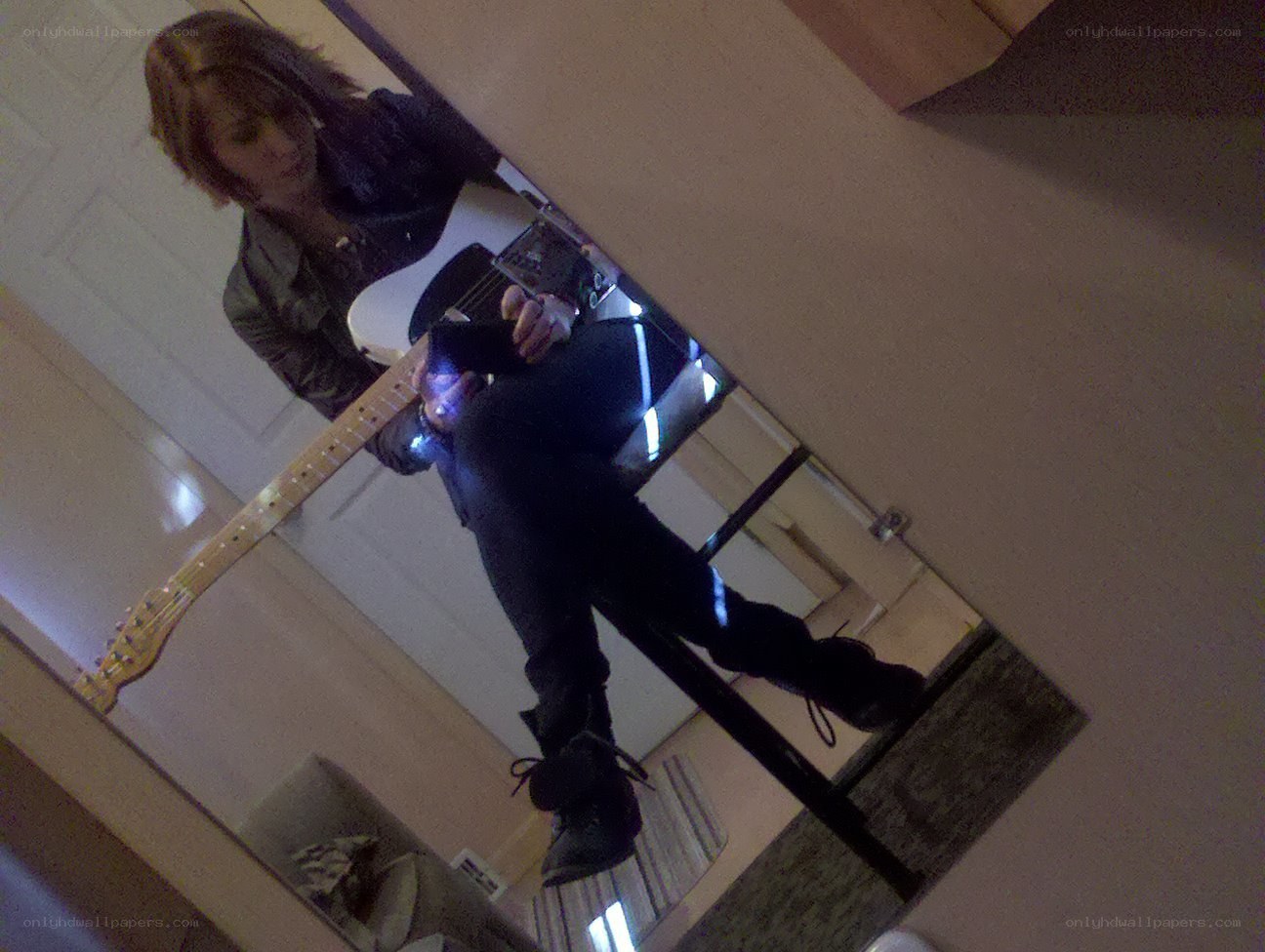 person playing guitar in mirror