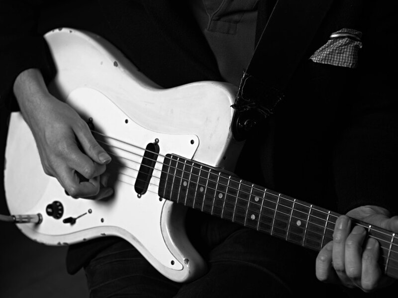 person playing white electric guitar