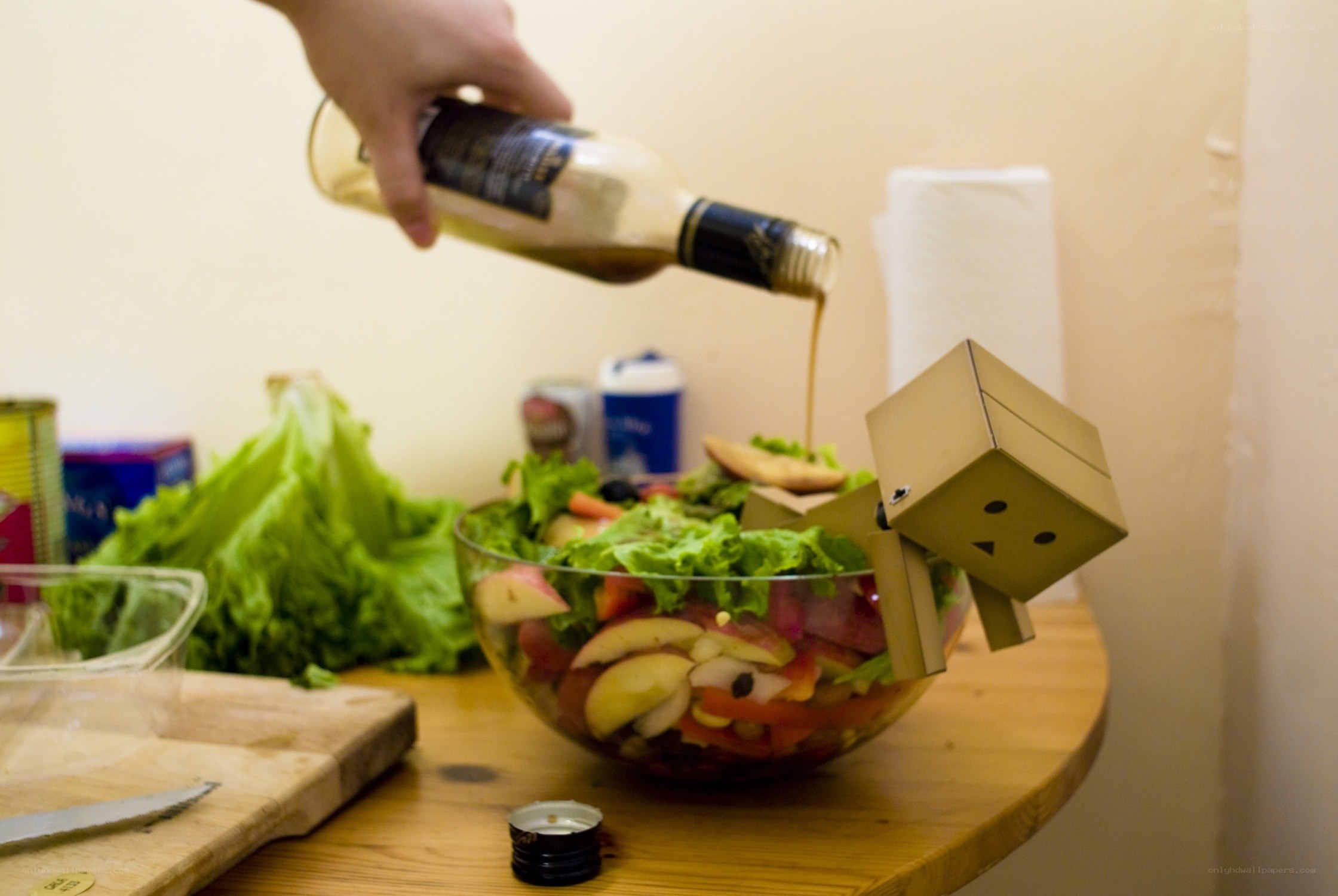 person pouring dressing on salad