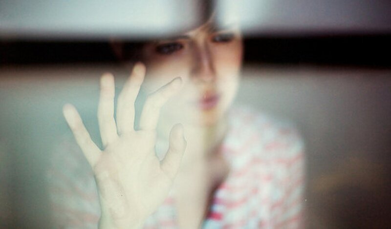 person pressing hand against glass