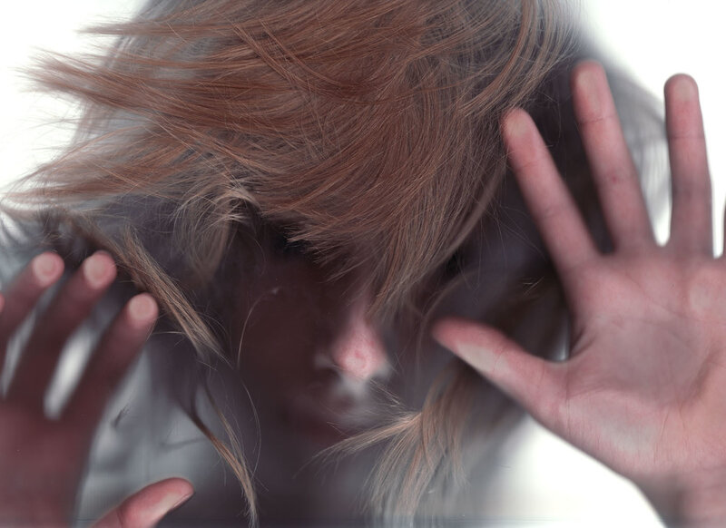 person pressing hands against glass