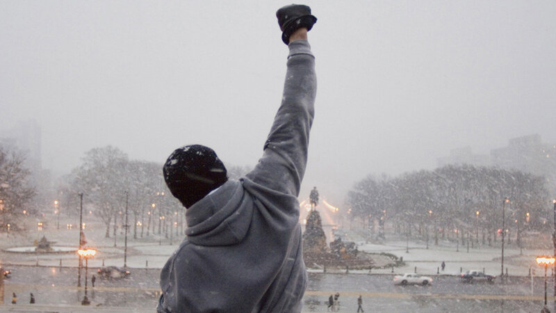 person raising fist in snow