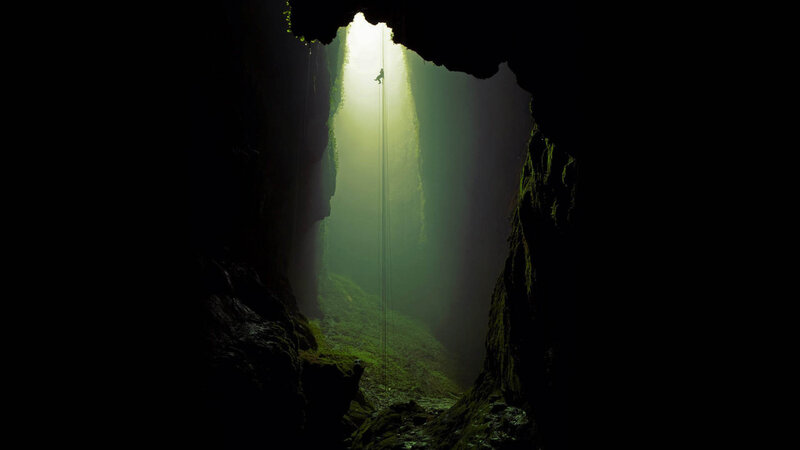 Person Rappelling in Cave — Black, Dramatic, Photograph