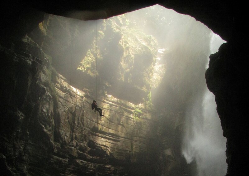 Person Rappelling in Cave — Black, Dramatic
