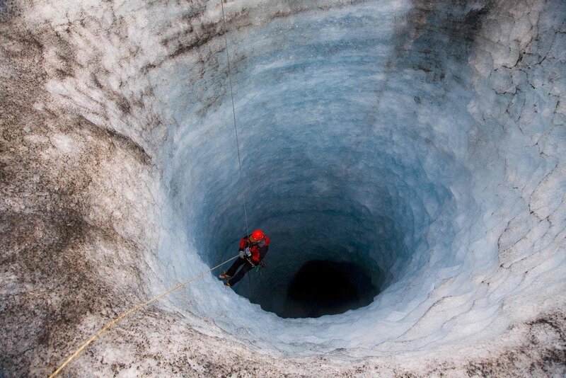 Person Rappelling into Ice Cave