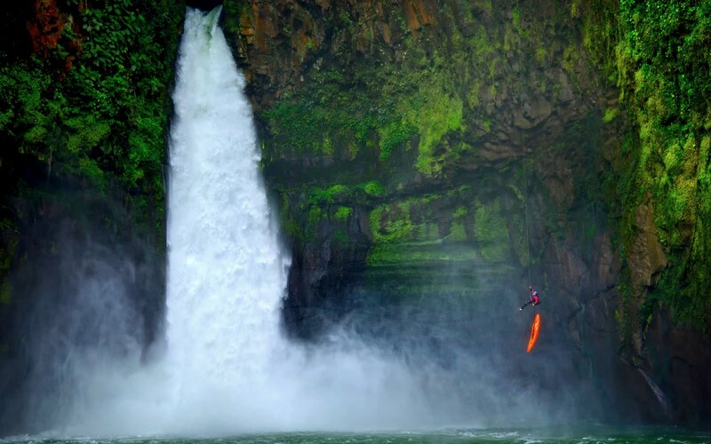 Person Rappelling Near Waterfall — Green