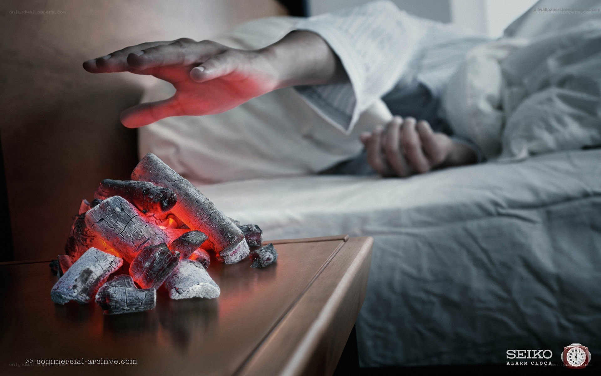 person reaching for glowing coals