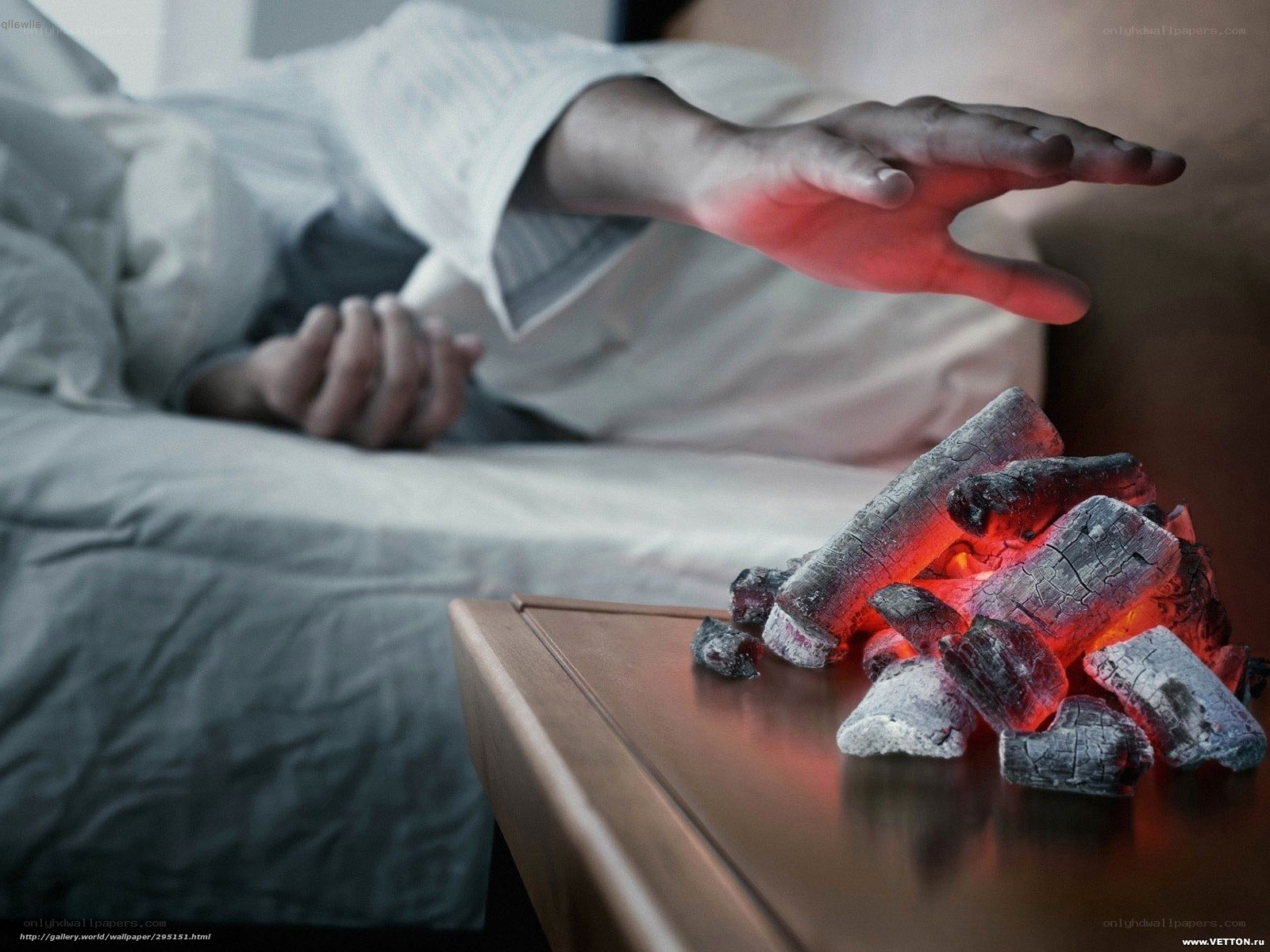 person reaching for glowing coals