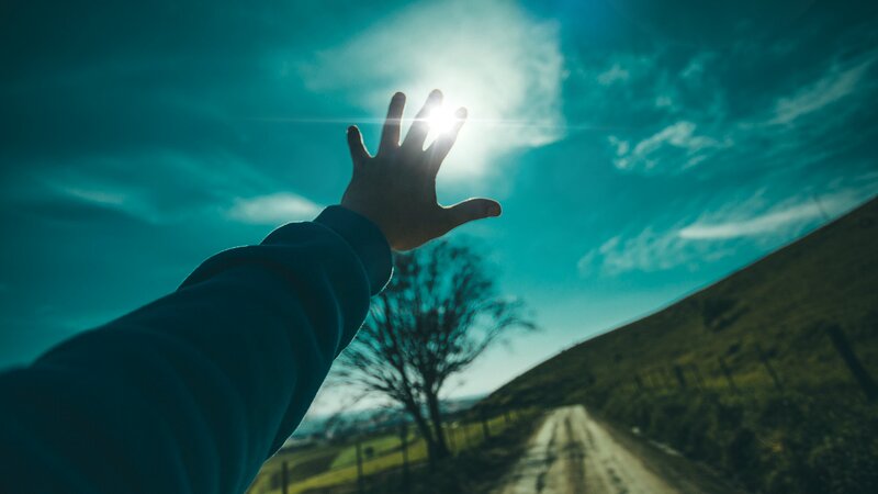 Person Reaching Toward Sun