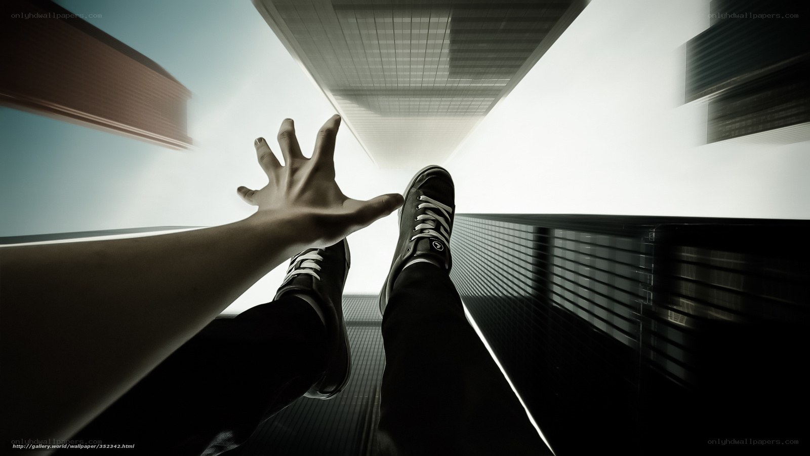 Person reaching up from high building