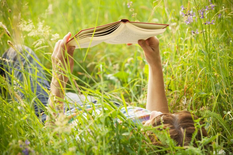 Person Reading Book in Grass
