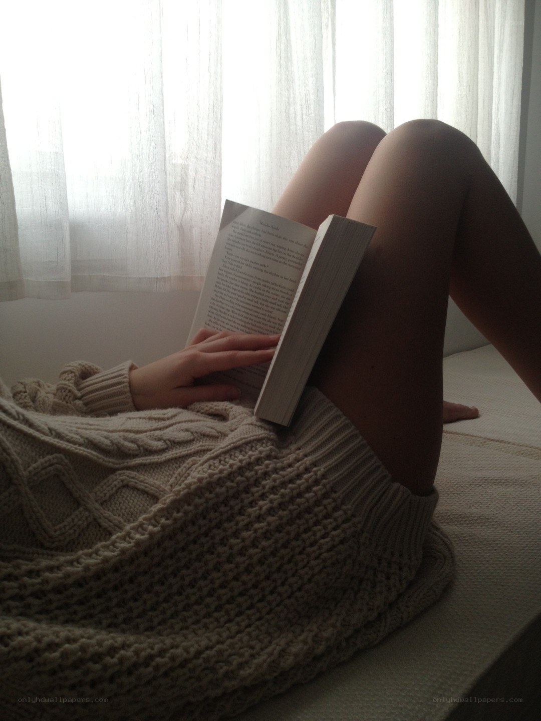 person reading book on bed