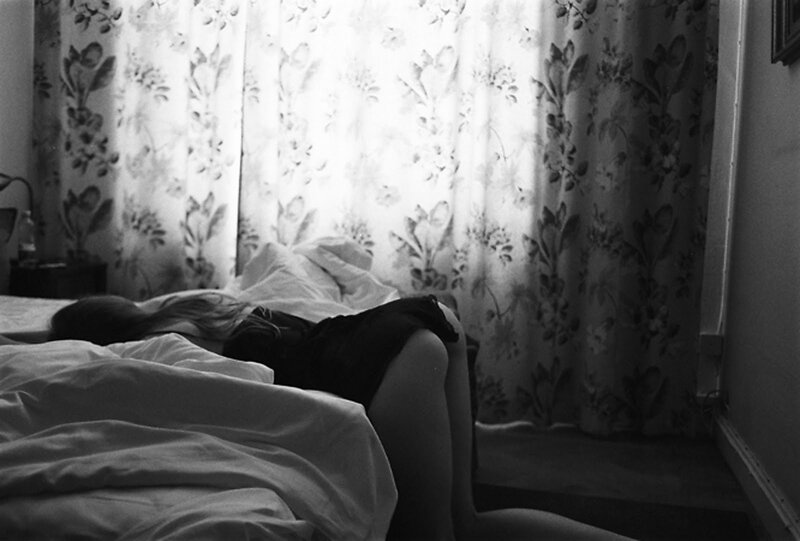 person resting on bed in bedroom