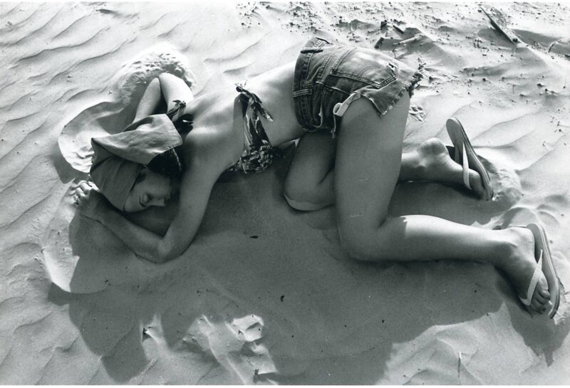 Person resting on sandy beach