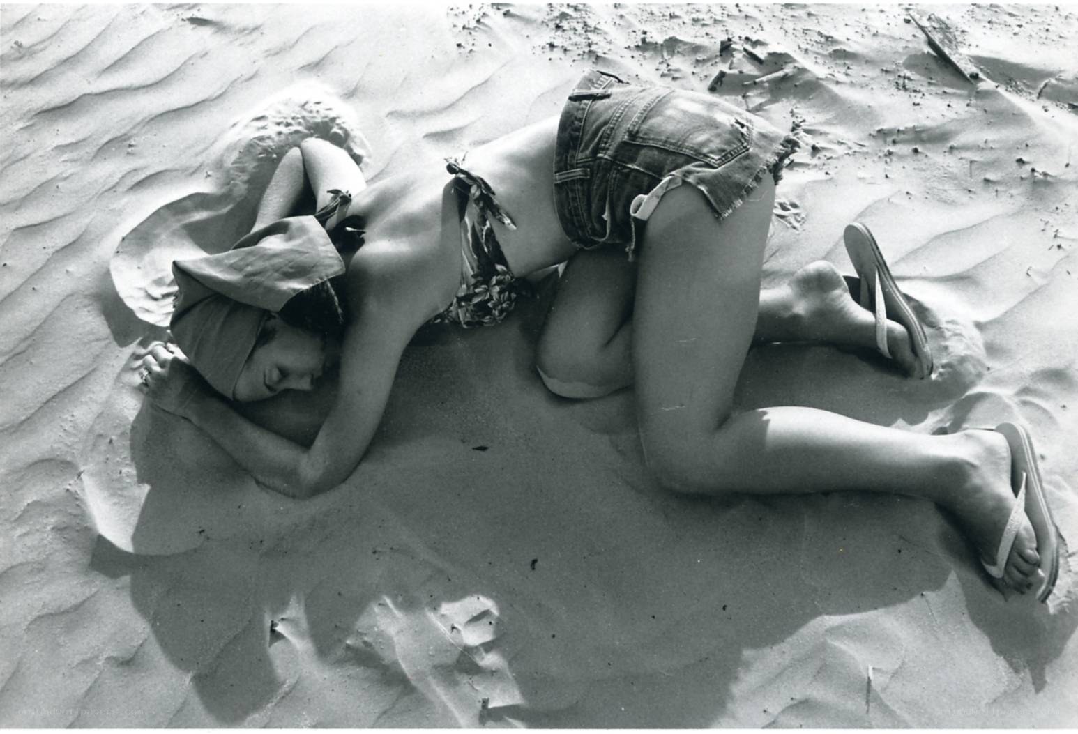 Person resting on sandy beach