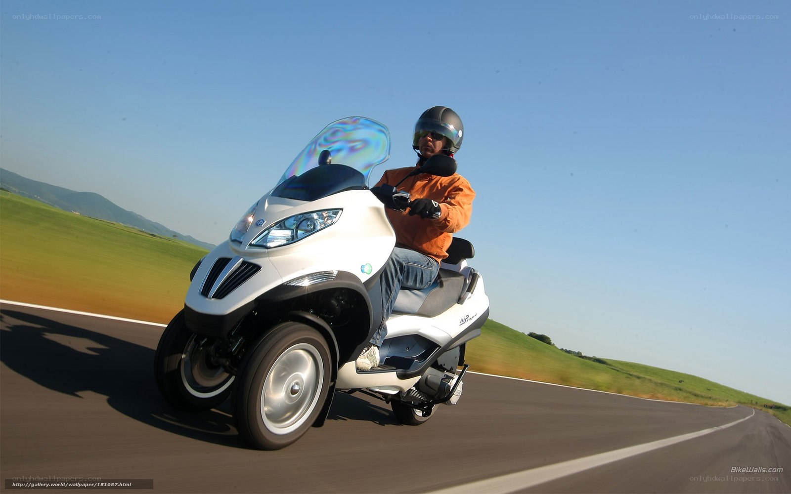 Person riding a three-wheeled scooter