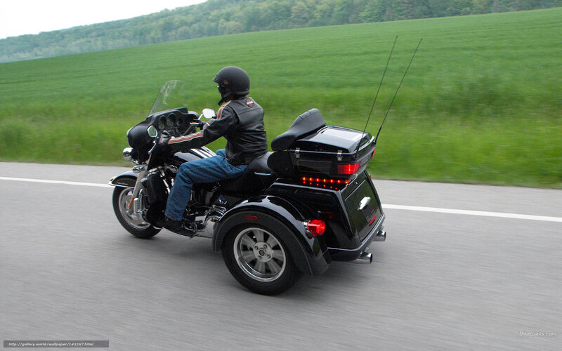 person riding a trike on a road