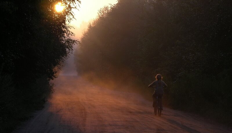 Person riding bike on dirt road