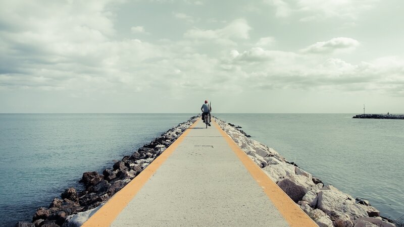 Person riding bike on pier
