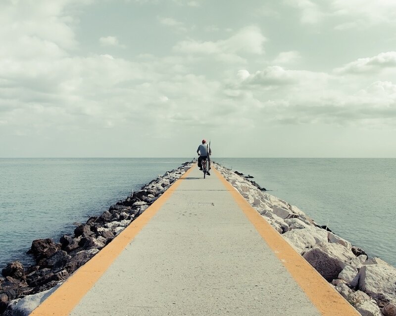 person riding bike on pier