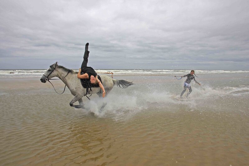 Person riding horse on beach