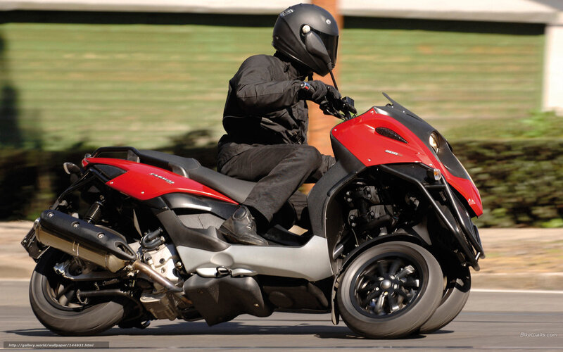 person riding red three-wheeled scooter