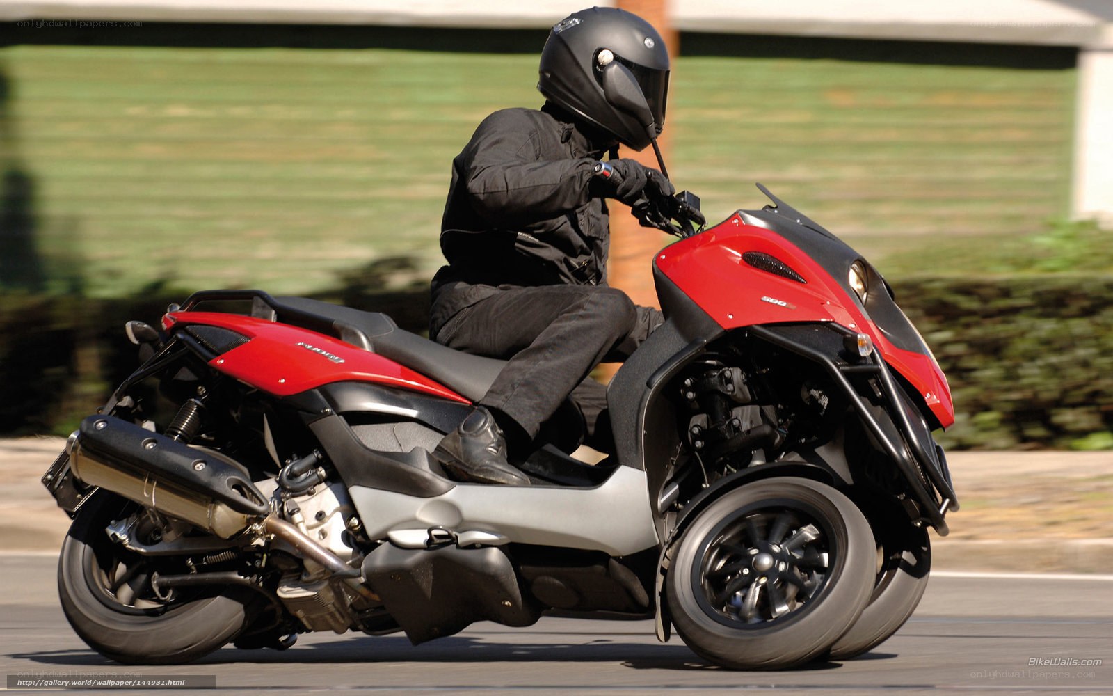 person riding red three-wheeled scooter