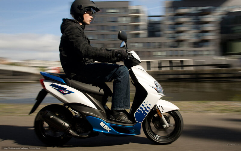 person riding scooter on city street