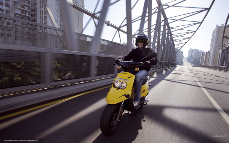 Person riding yellow scooter on bridge