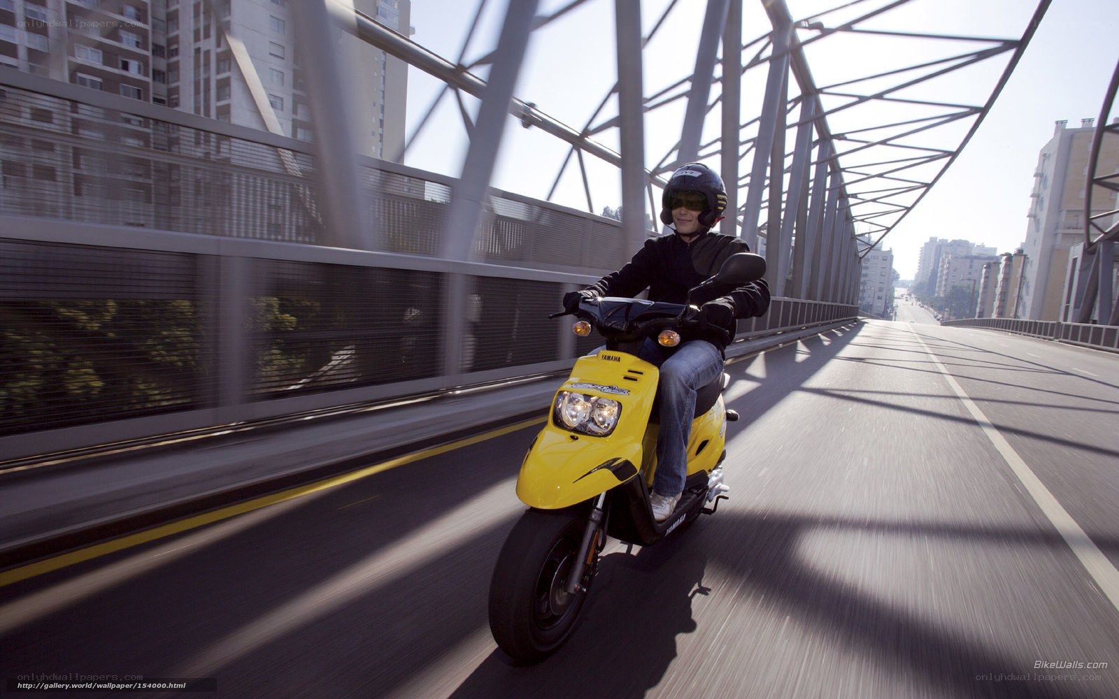 Person riding yellow scooter on bridge