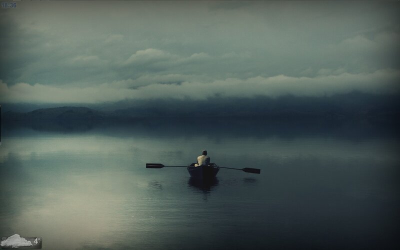 Person rowing boat on calm lake
