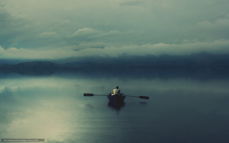 Person rowing boat on calm lake
