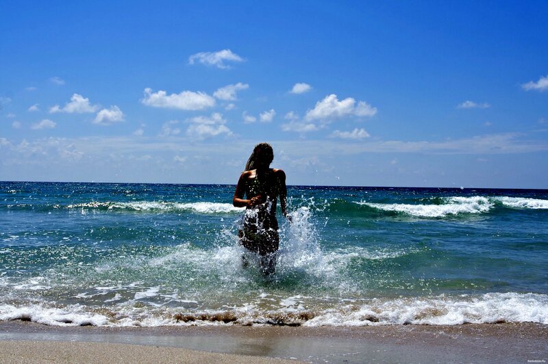 person running into ocean waves
