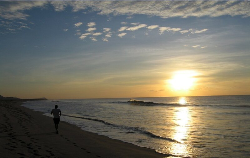Person running on beach at sunset