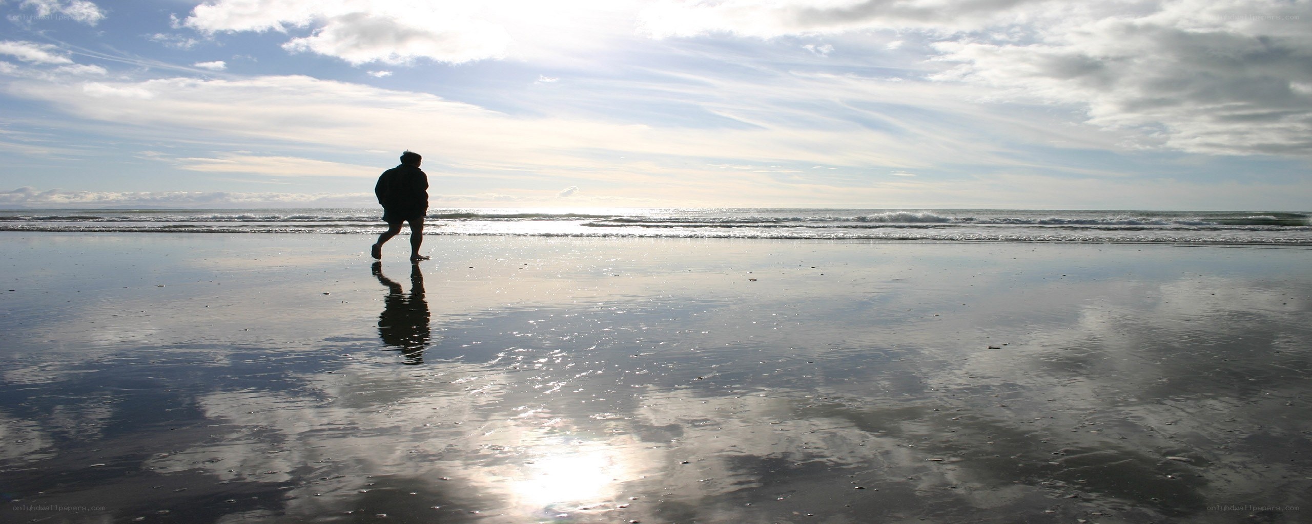 Person running on beach at sunset