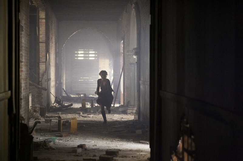 Person running through ruined hallway