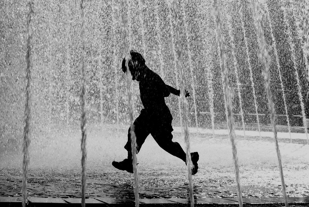 Person running through water jets
