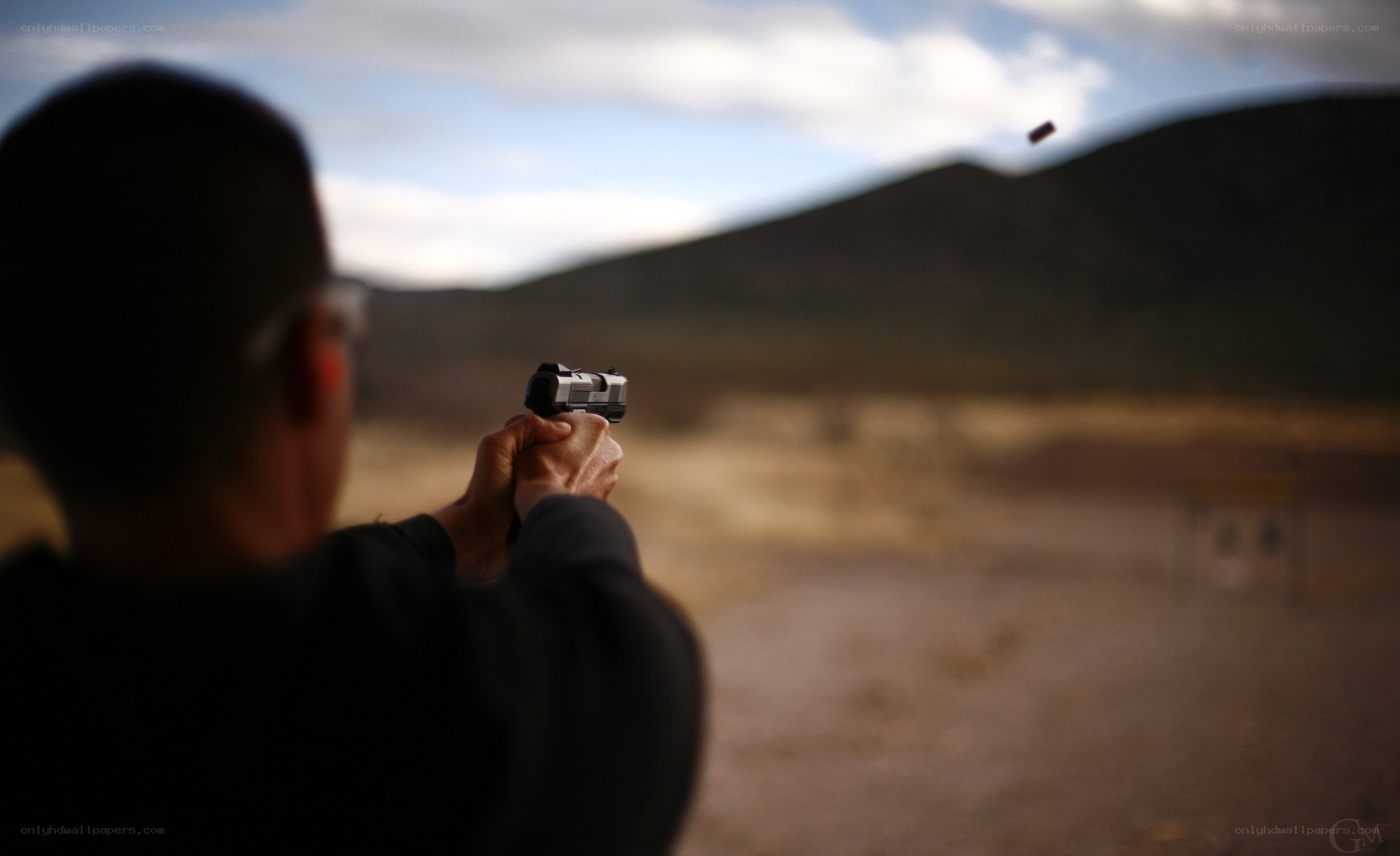 Person shooting handgun at range