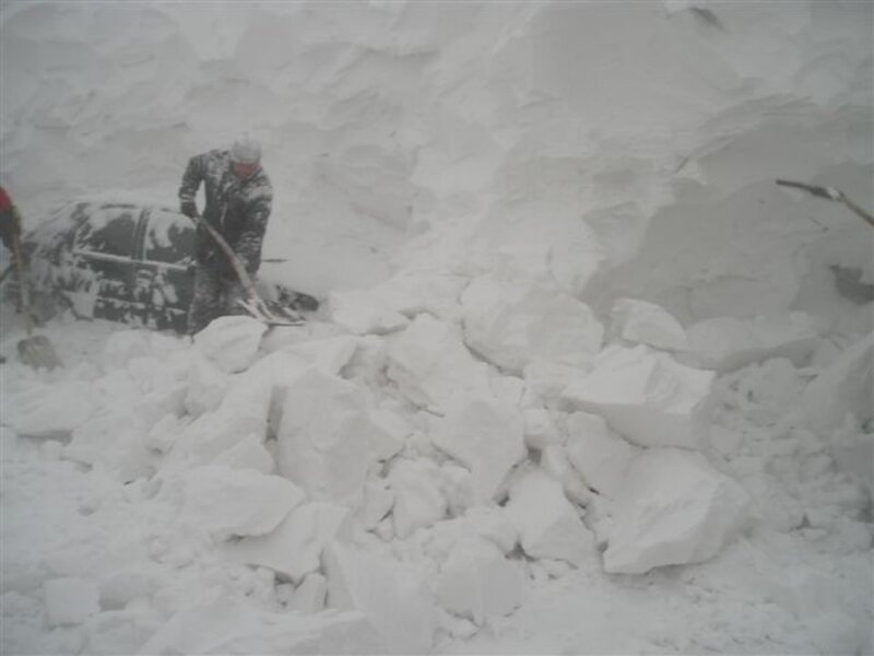 Person shoveling snow from car