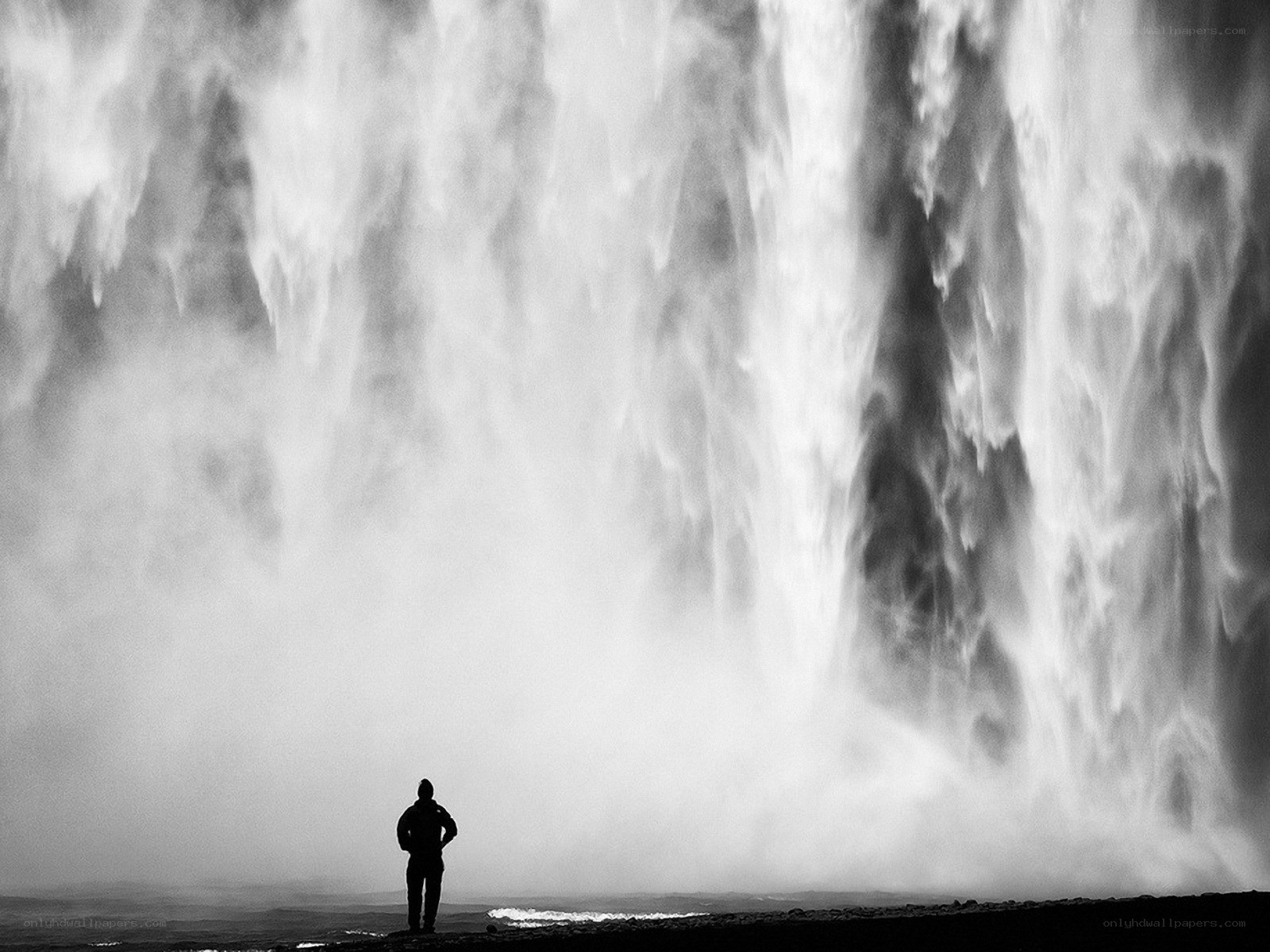 Person silhouetted by waterfall