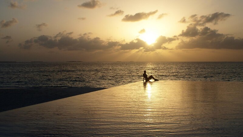 Person Sitting at Pool Edge