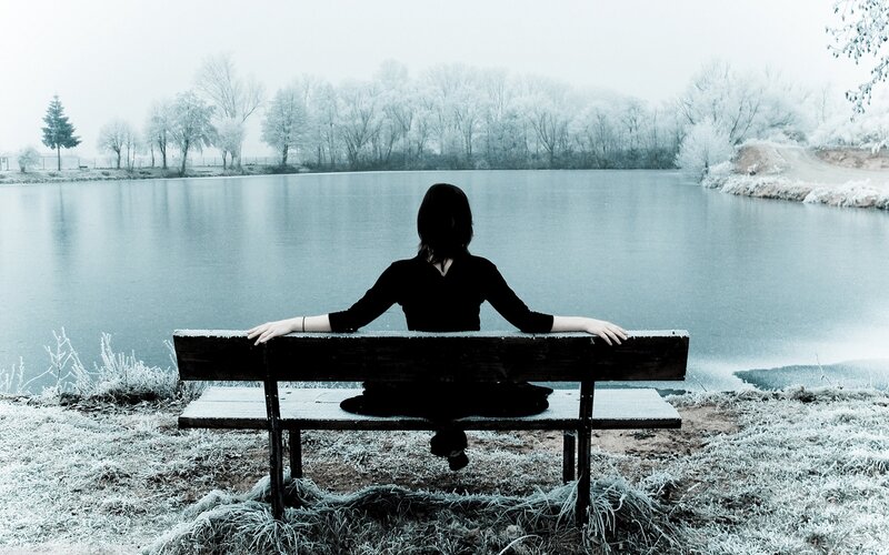 Person sitting by a lake