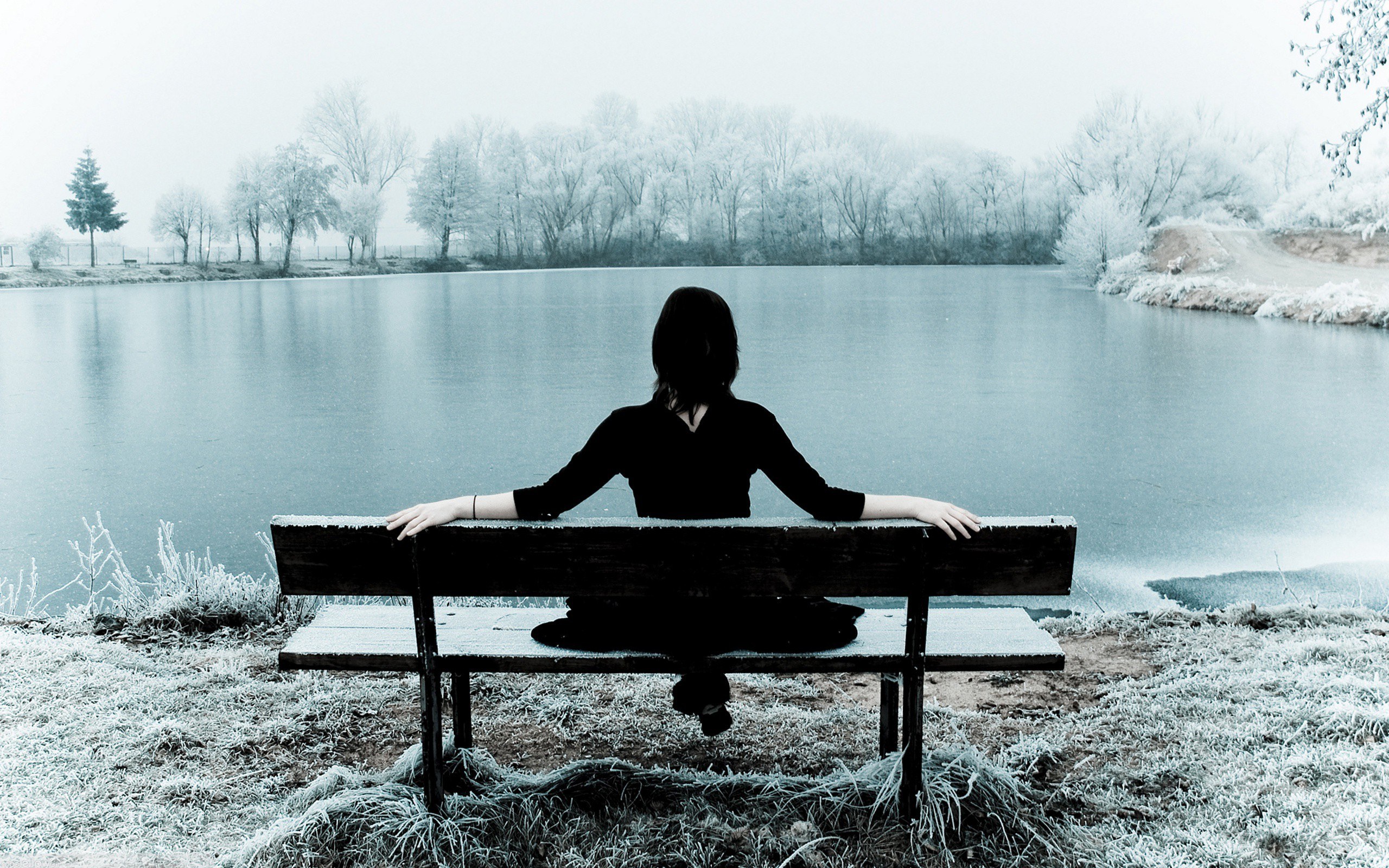 Person sitting by a lake
