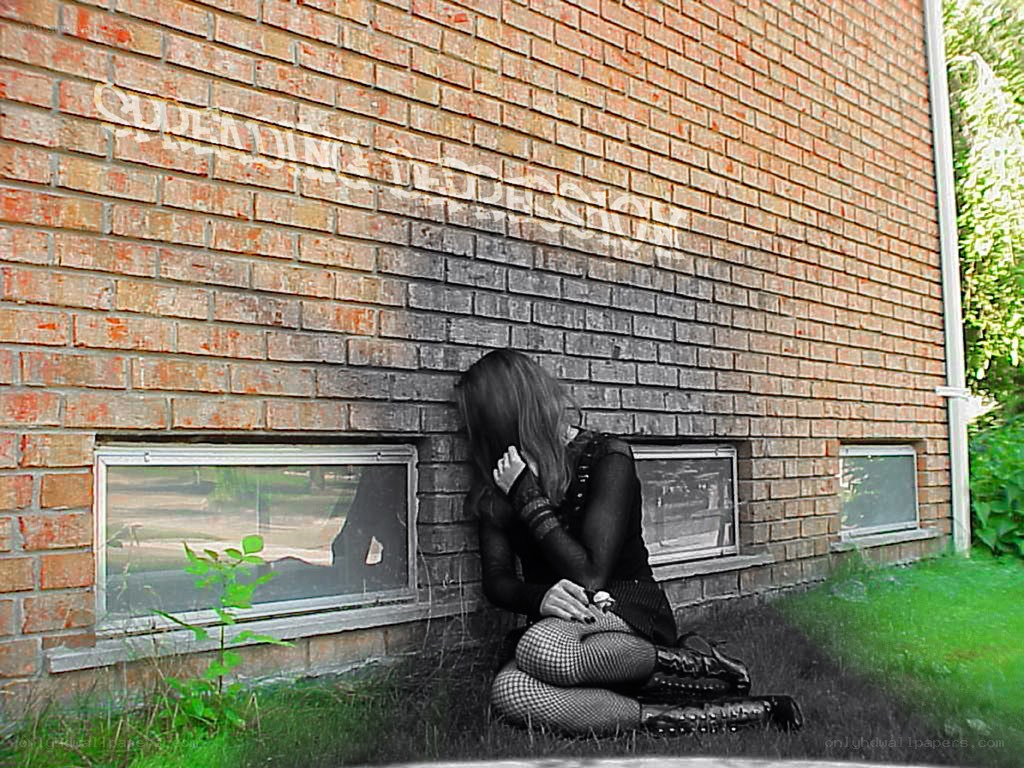 person sitting by brick wall