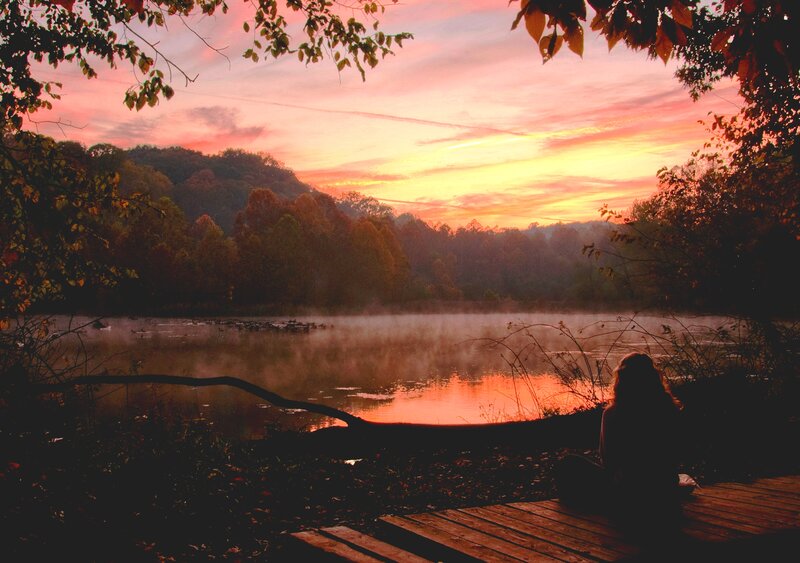 Person Sitting by Lake — Orange, Serene