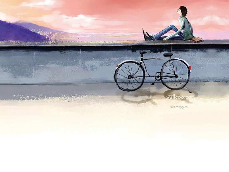 Person sitting by the sea at sunset