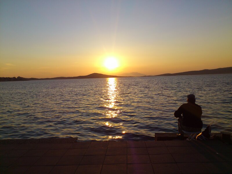 Person Sitting by Water — Blue